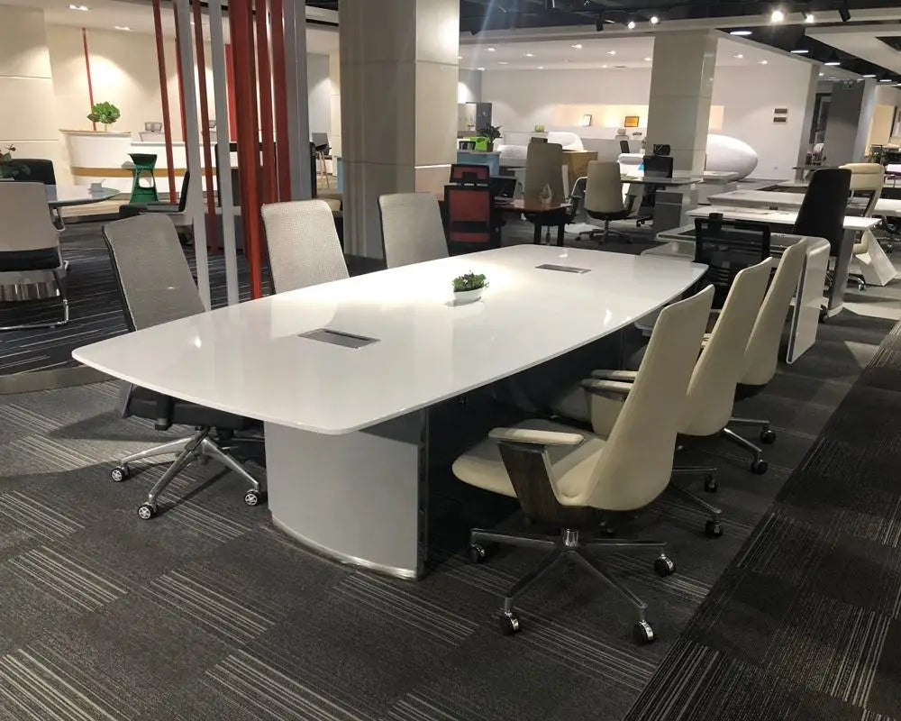 Modern white executive conference table with sleek minimalist design and integrated power ports for office use