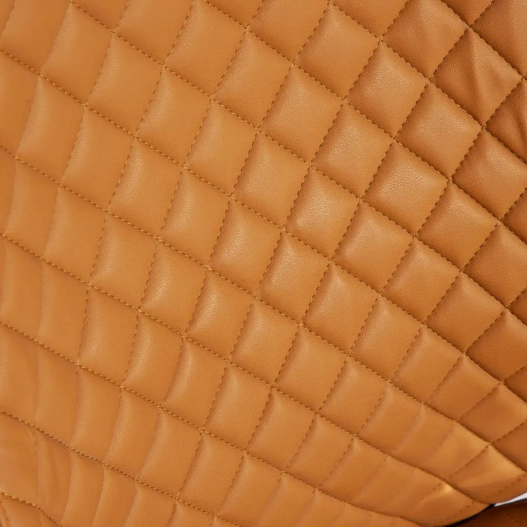 Tan quilted leather diamond-stitched surface of the back side of a high back office executive chair beige