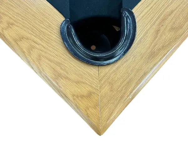 Black metal pool table pocket with smooth curved rim set in light oak wooden frame on luxury handicraft 8ft natural oak pool table